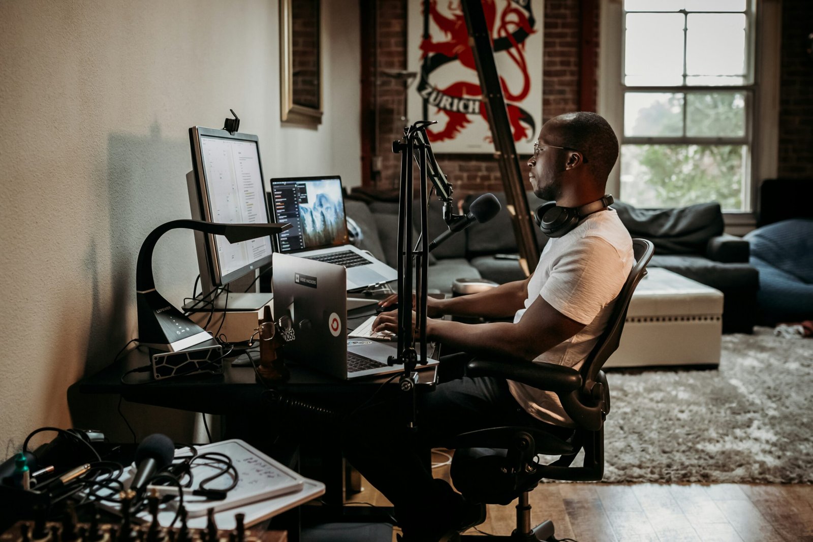 Young man sits at his desk facing his monitor.
